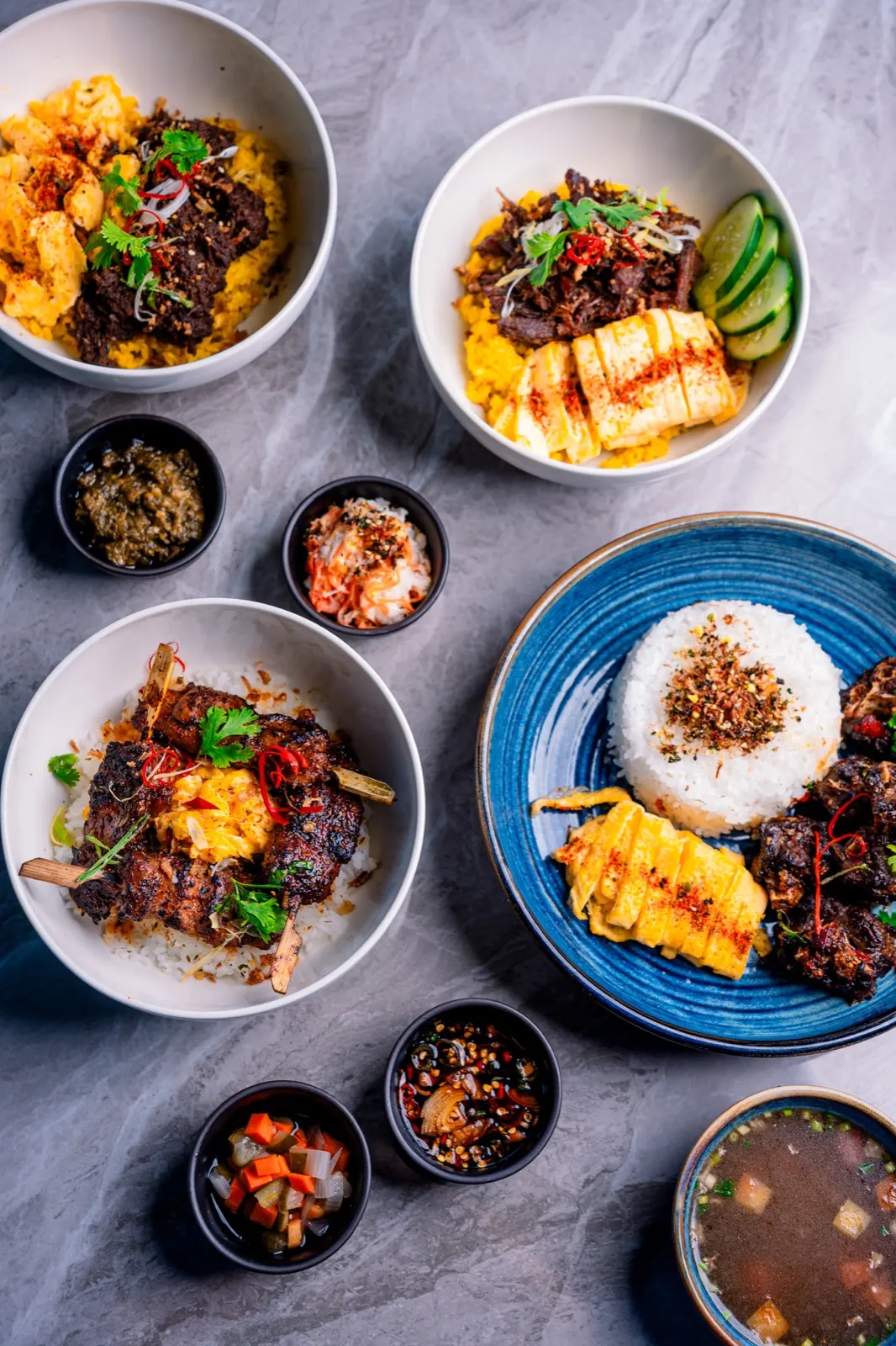 Signature Bobi Bowl dishes: rice bowls, satay and sambal served together